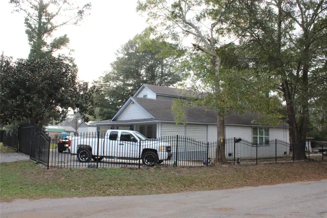a front view of a house with a garden and tree