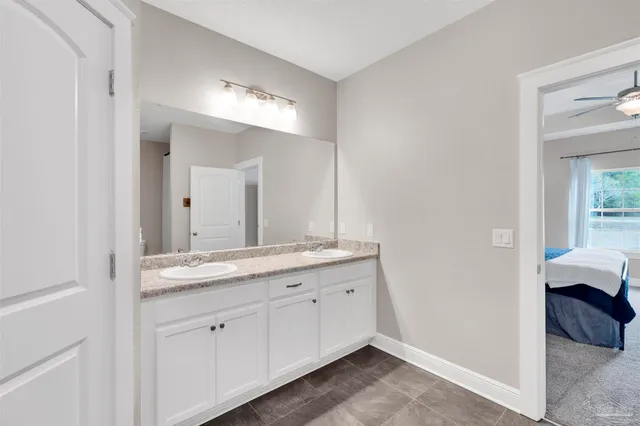a en suite bathroom with a granite countertop sink and a mirror