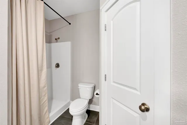 a bathroom with a toilet and a shower