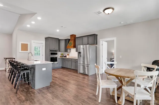 a kitchen with a table chairs refrigerator and microwave