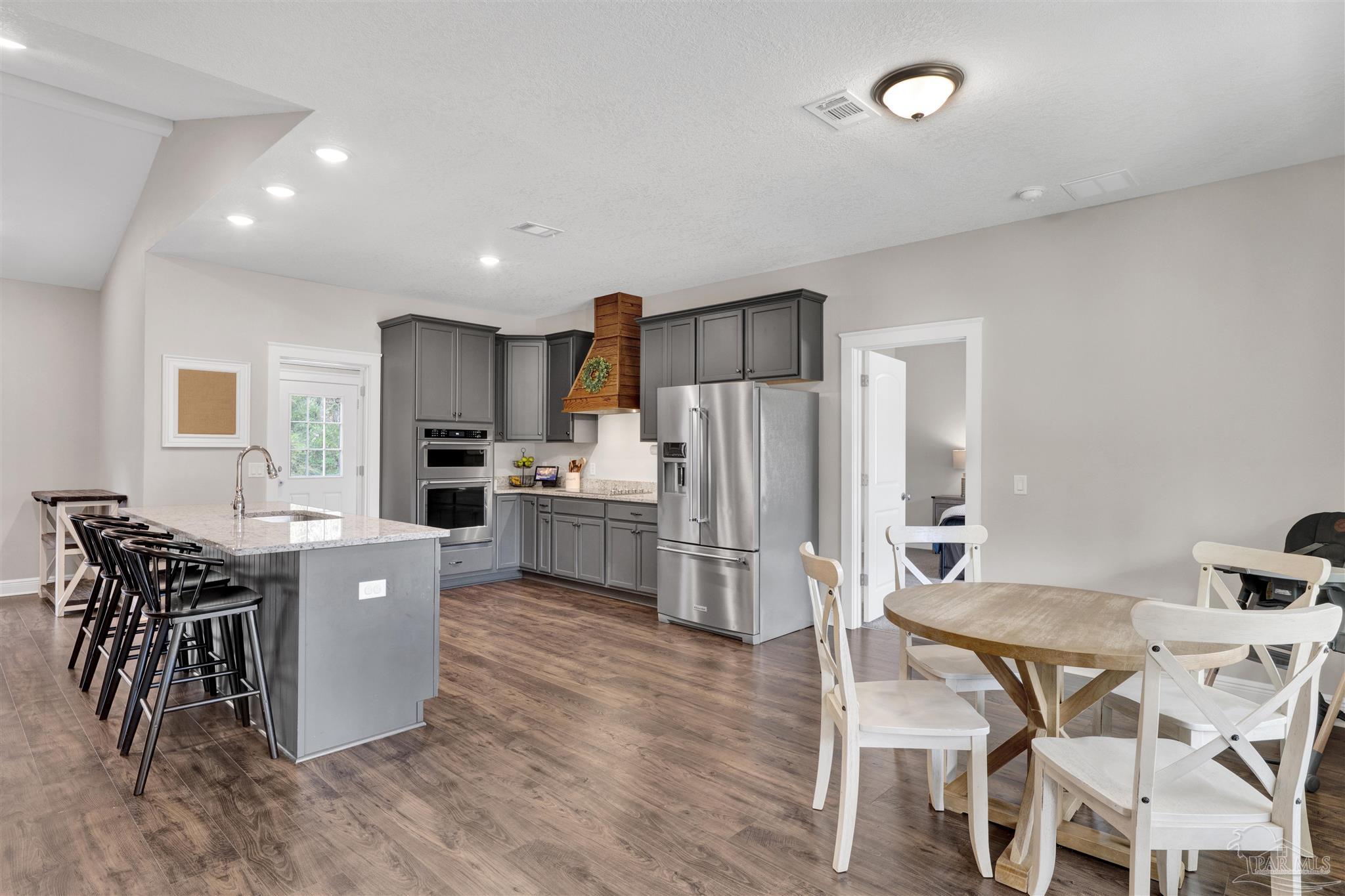 4363 Morristown Road Jay, FL 32565 - Photo 8 of 37 a kitchen with a table chairs refrigerator and microwave