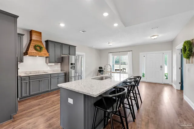 a kitchen with stainless steel appliances granite countertop a kitchen island a stove and a sink