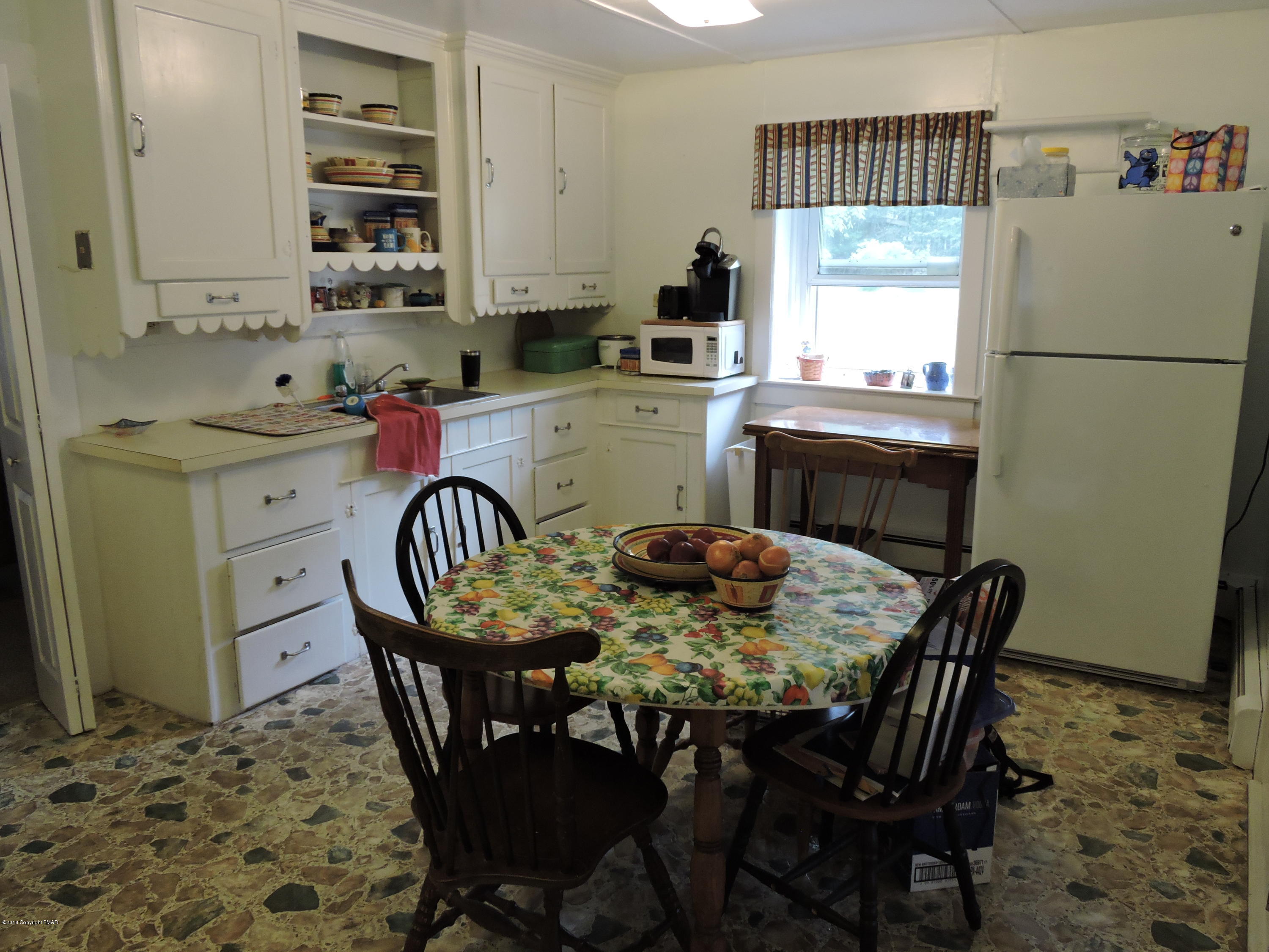 813 Stokes Mill Road Stroudsburg, PA 18360 - Photo 8 of 20 a kitchen with a table chairs a sink dishwasher a refrigerator with a dining table and chairs