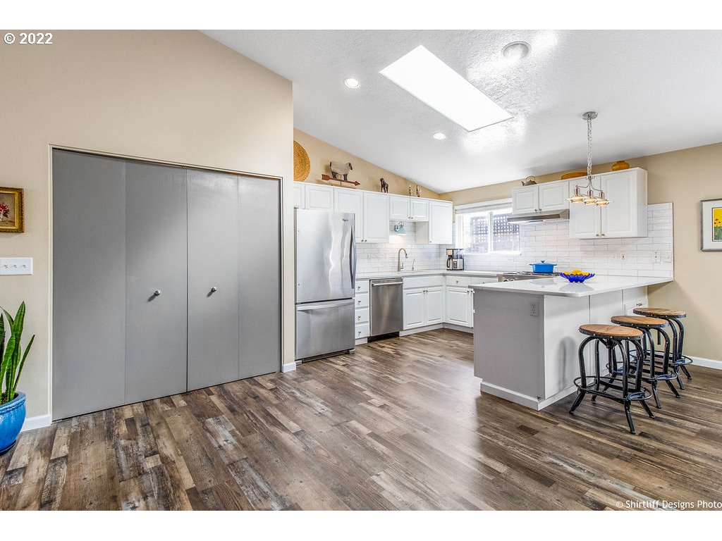 3565 Castrey Street Eugene, OR 97404 - Photo 8 of 30 a kitchen with refrigerator cabinets and wooden floor