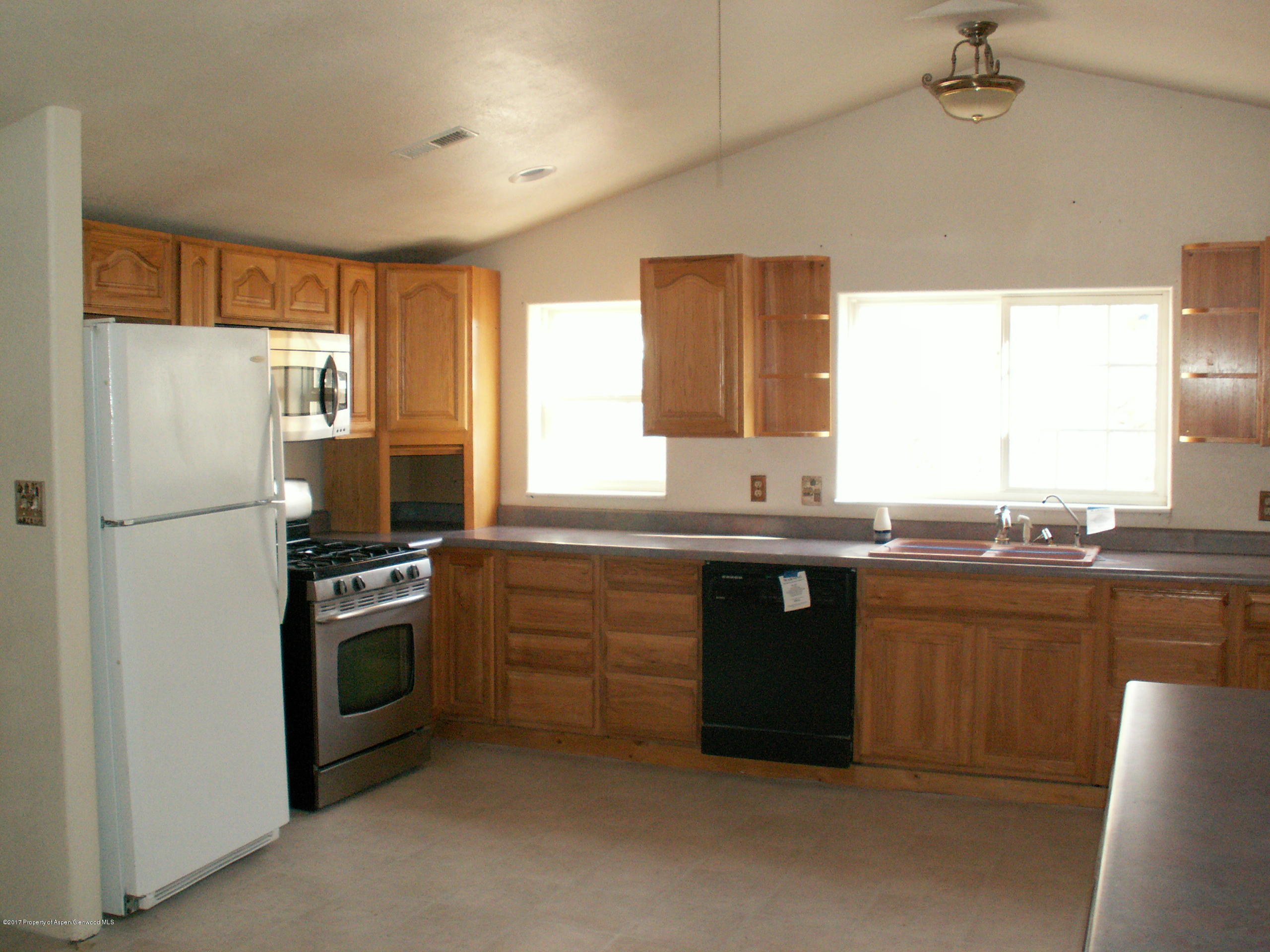 826 Randolph Avenue Rifle, CO 81650 - Photo 5 of 21 a kitchen with stainless steel appliances granite countertop a refrigerator and a sink