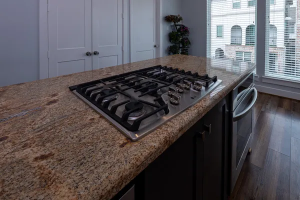 a kitchen with granite countertop a stove and a sink
