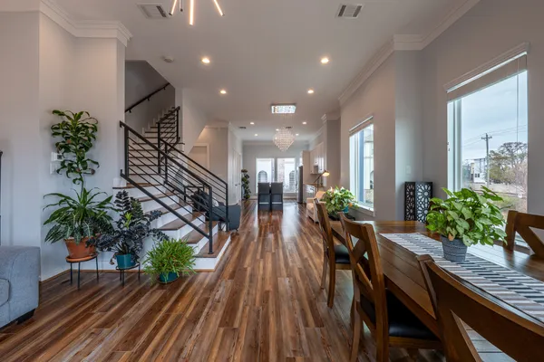 a hallway with wooden floor table and chairs