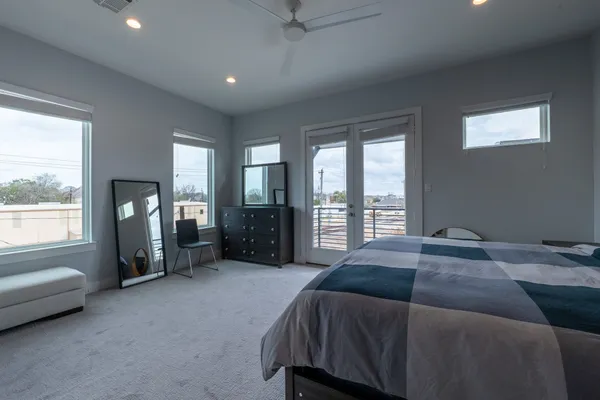 a bed sitting in a spacious bedroom next to a window
