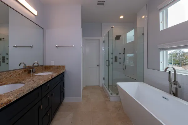 a bathroom with a granite countertop sink a toilet a mirror and shower