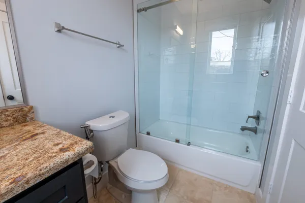 a bathroom with a granite countertop toilet sink and shower