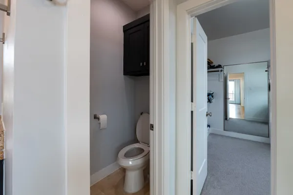 a bathroom with a granite countertop toilet and a sink