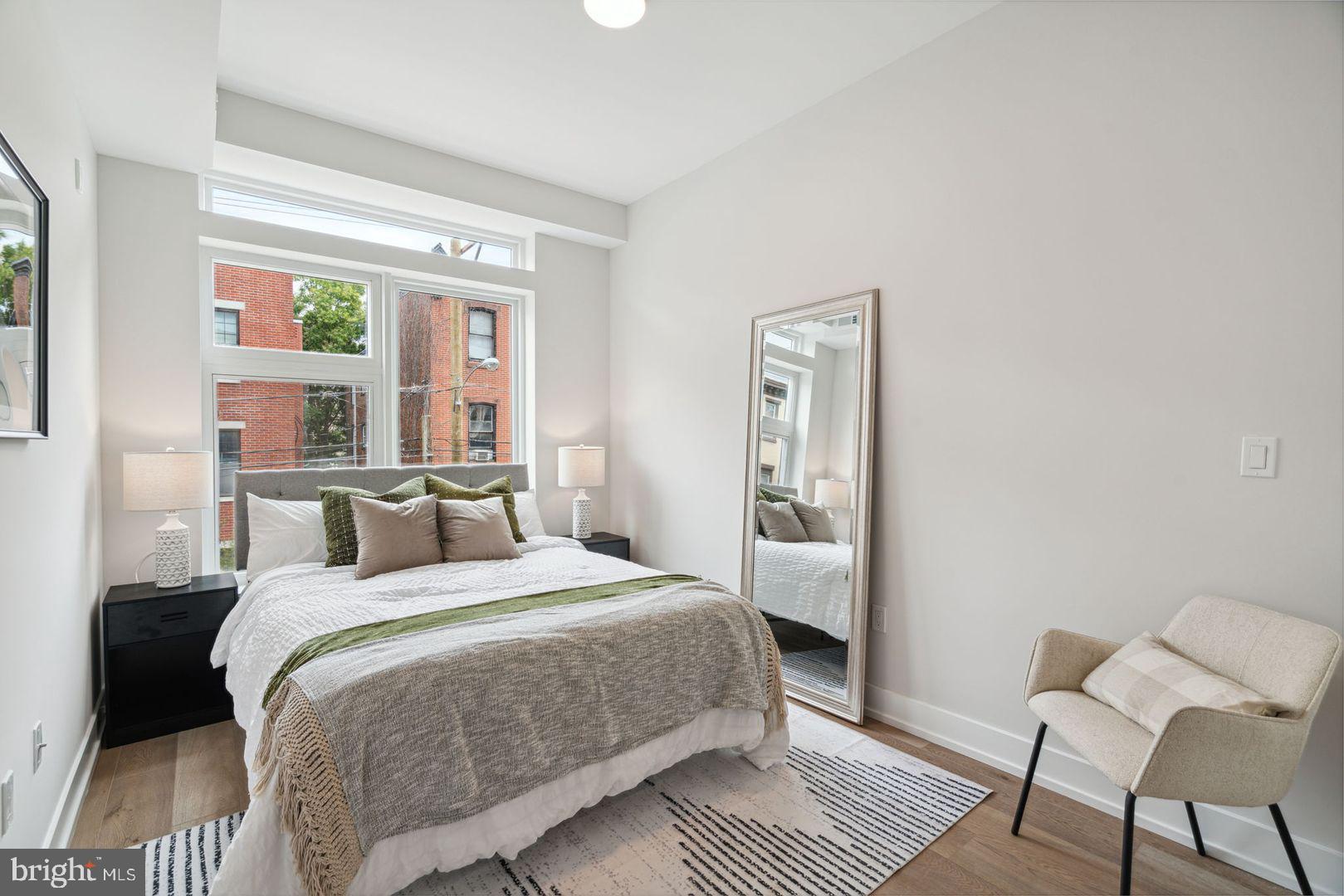 720 West Thompson Street, Unit 2B316 Philadelphia, PA 19122 - Photo 15 of 32 a bedroom with a bed wooden floor and a rug