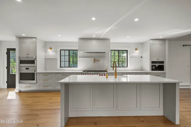 a kitchen that has a stove and a wooden floor