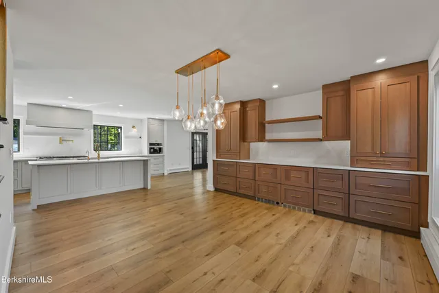 a view of a kitchen with wooden floor and a living room