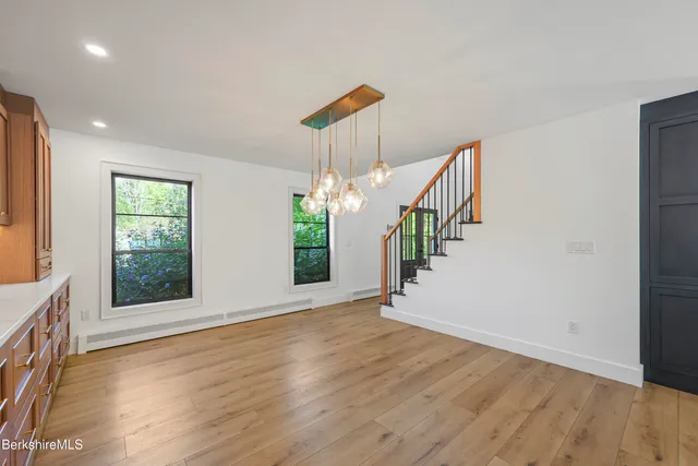 a large kitchen with stainless steel appliances lots of counter space and wooden floor