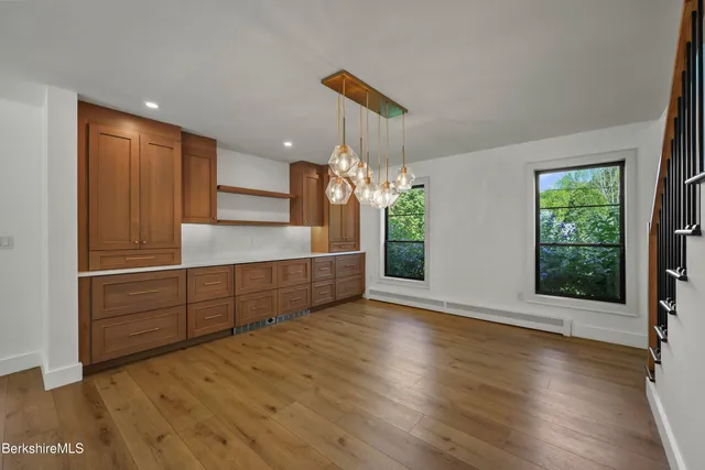 a open kitchen with stainless steel appliances granite countertop a stove and a large window