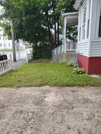 a view of a house with a yard and sitting area