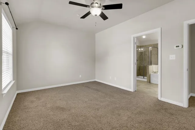 an empty room with fan and windows