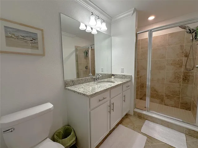a bathroom with a granite countertop sink a toilet and shower