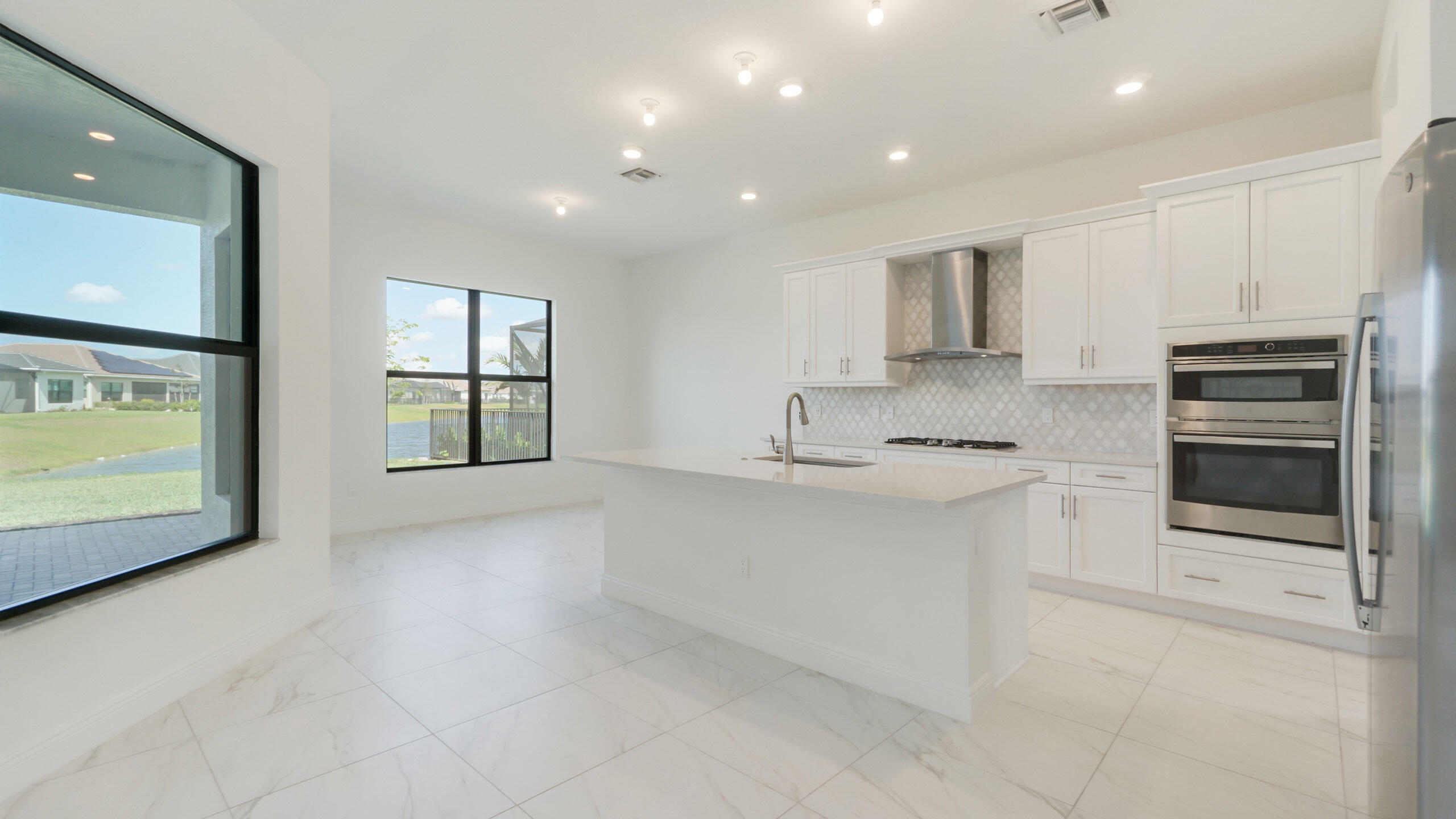 15739 Cresswind Place Westlake, FL 33470 - Photo 7 of 48 a kitchen with stainless steel appliances granite countertop a stove a sink and a microwave