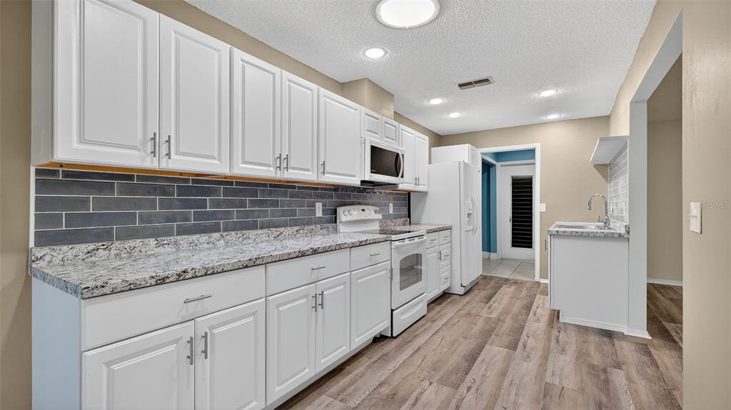 7280 Scotland Circle Weeki Wachee, FL 34613 - Photo 13 of 42 a kitchen with granite countertop a sink stainless steel appliances and cabinets