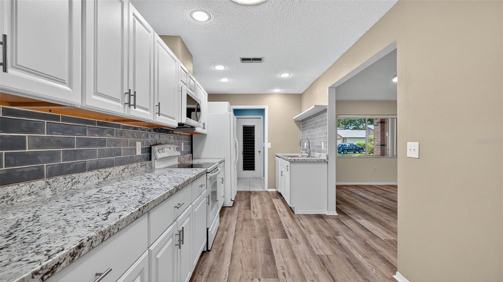 7280 Scotland Circle Weeki Wachee, FL 34613 - Photo 14 of 42 a kitchen with granite countertop cabinets stainless steel appliances and a counter space