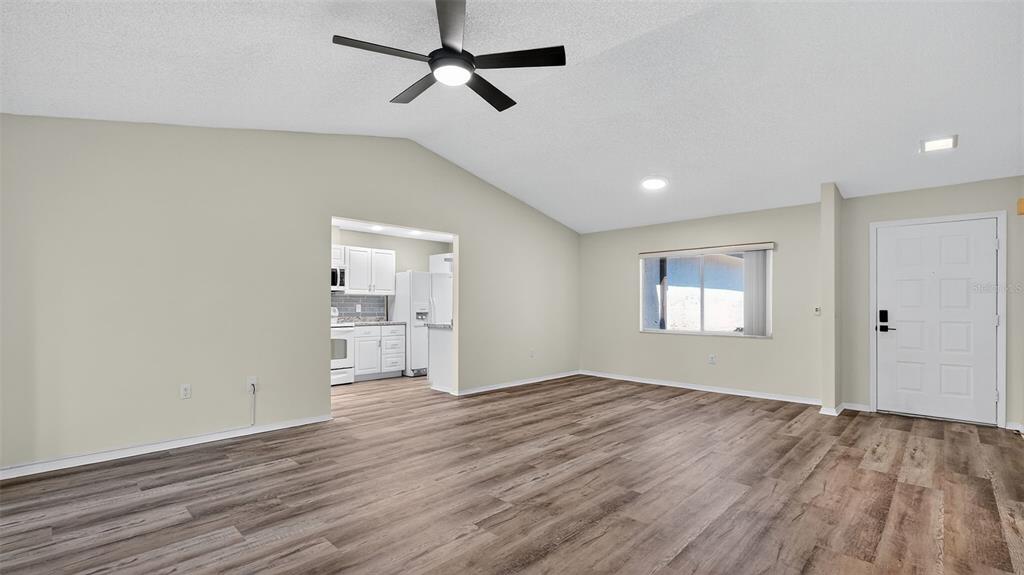 7280 Scotland Circle Weeki Wachee, FL 34613 - Photo 17 of 42 a view of empty room with wooden floor and ceiling fan