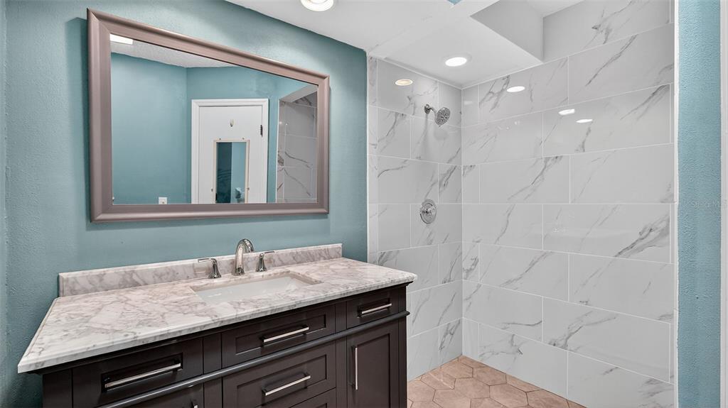 7280 Scotland Circle Weeki Wachee, FL 34613 - Photo 25 of 42 a bathroom with a granite countertop sink a mirror and shower