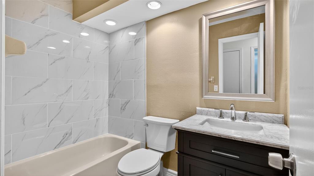 7280 Scotland Circle Weeki Wachee, FL 34613 - Photo 30 of 42 a bathroom with a granite countertop sink toilet and shower