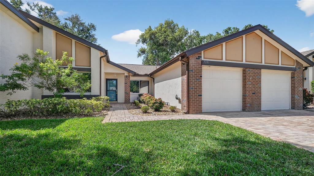 7280 Scotland Circle Weeki Wachee, FL 34613 - Photo 3 of 42 a front view of a house with a yard and porch