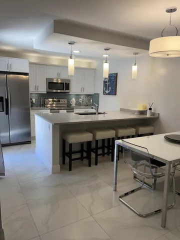 a kitchen with kitchen island a table and chair in it