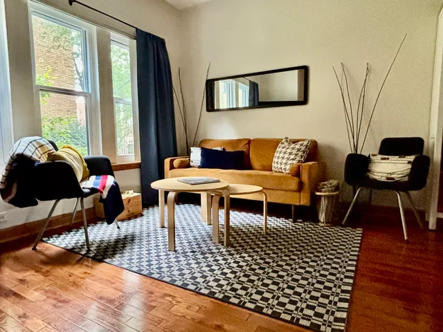 a living room with furniture a rug and a table