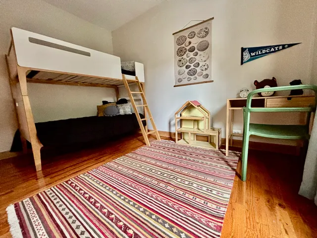 a view of a bedroom with furniture and wooden floor