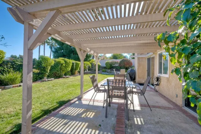 a view of a patio with table and chairs potted plants with floor to ceiling window
