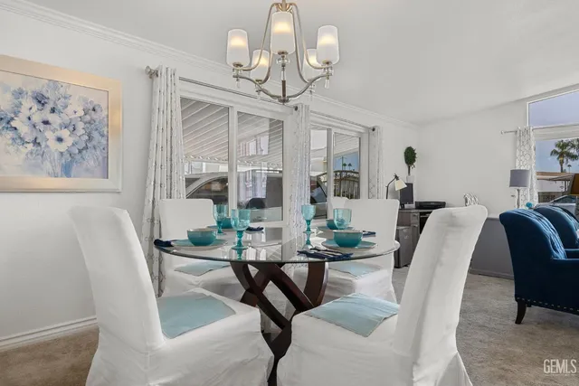 a view of a dining room with furniture a chandelier and a window