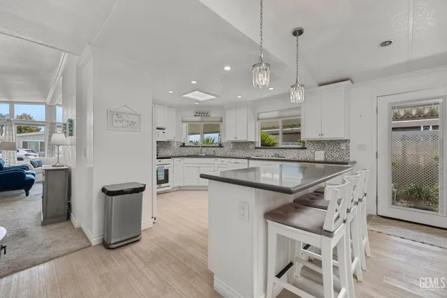 a kitchen with granite countertop a sink appliances and cabinets