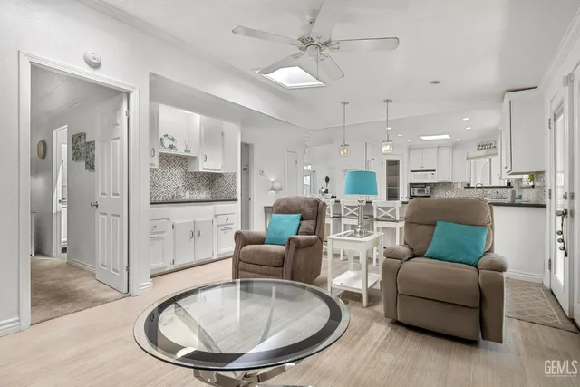 a living room with furniture a large window and kitchen view