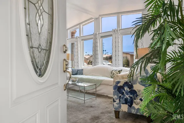 a living room with furniture a window and a palm tree