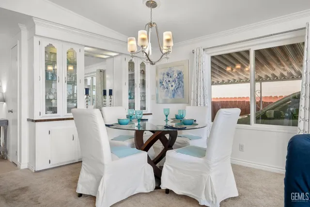 a view of a dining room with furniture a chandelier and wooden floor