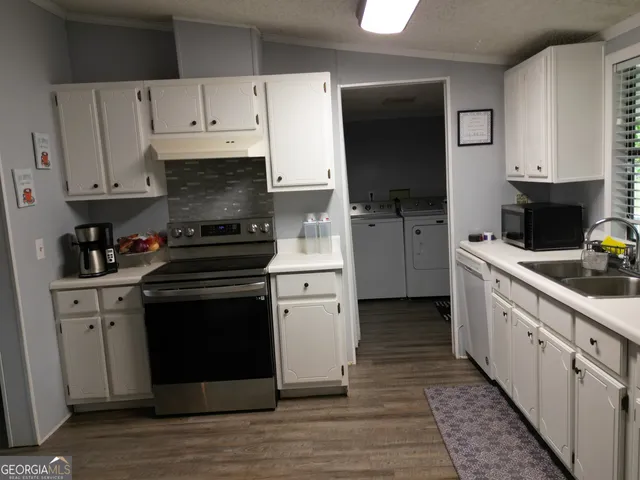 a kitchen with cabinets stainless steel appliances and a sink