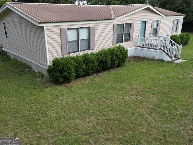 a view of a house with a backyard and a garden