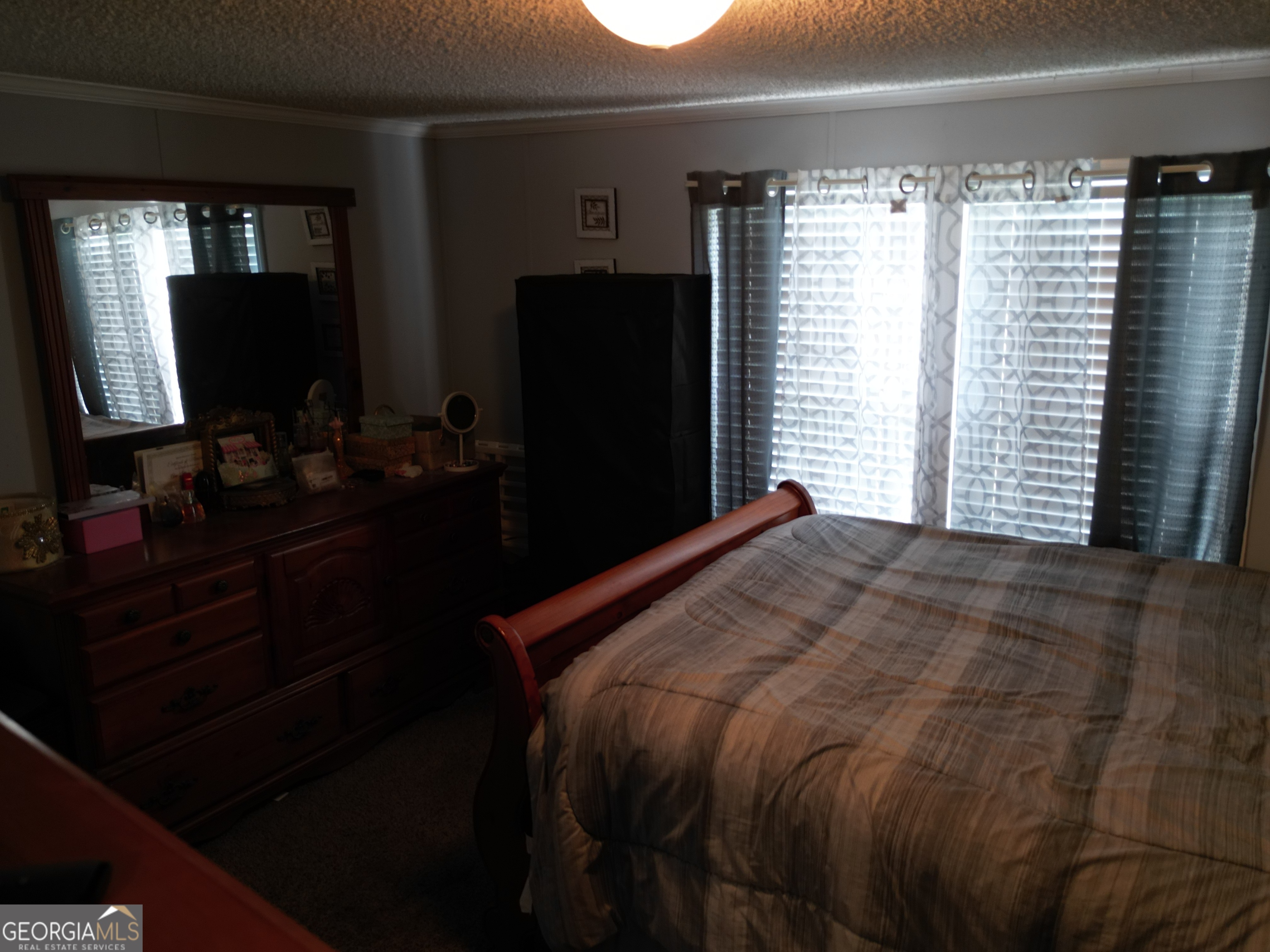 693 Old Quitman Annex Road Adel, GA 31620 - Photo 25 of 30 a bedroom with a bed and a flat tv screen next to a window
