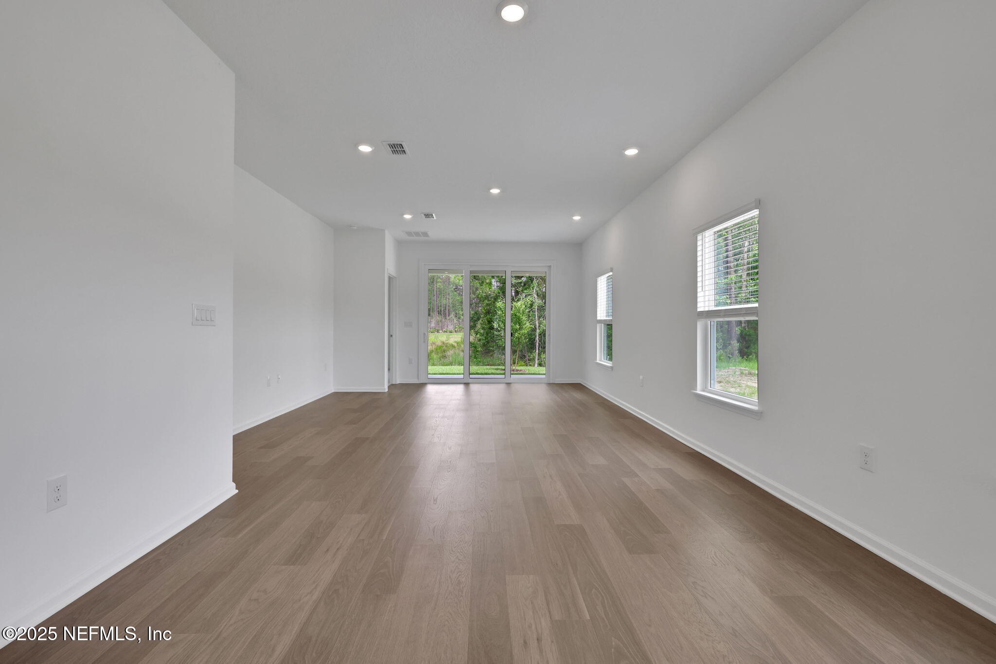 191 Bluegrass Way St. Augustine, FL 32092 - Photo 15 of 62 a view of an empty room with wooden floor and a window