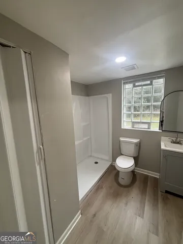 a bathroom with a toilet sink a window and vanity