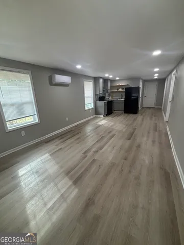 a view of empty room with a kitchen and a window