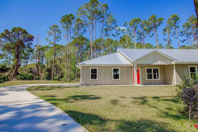 an empty room with wooden floor ceiling fan and windows