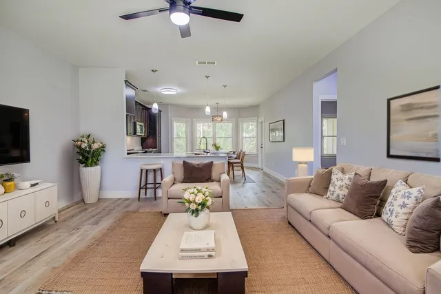 a kitchen with stainless steel appliances granite countertop a stove top oven a sink dishwasher and a microwave oven on the wooden floor