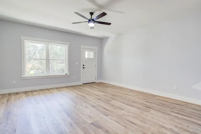 a view of a house with a yard and potted plants
