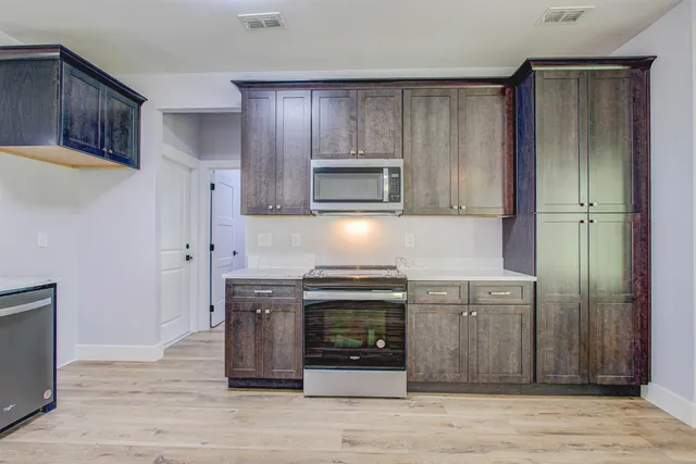 a kitchen with stainless steel appliances granite countertop a stove microwave and refrigerator
