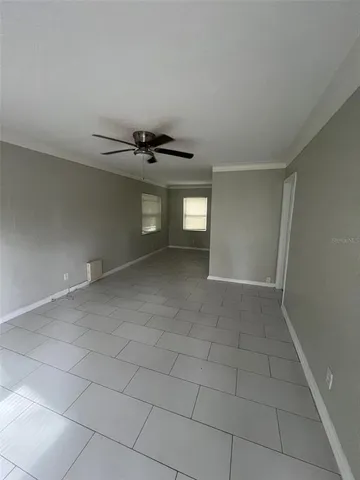 an empty room with windows and fan